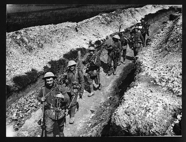 (6) Folio 19450 - Troops in steel helmets moving along a communication trench fully equipped for their various duties