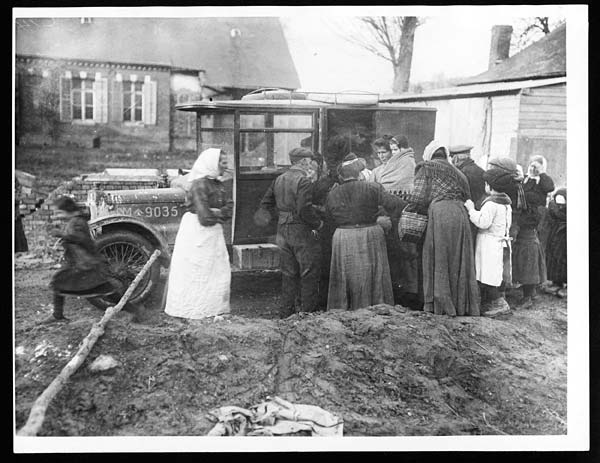 (119) C.1400 - Inhabitants of a newly captured village gather round a British motor car to receive food