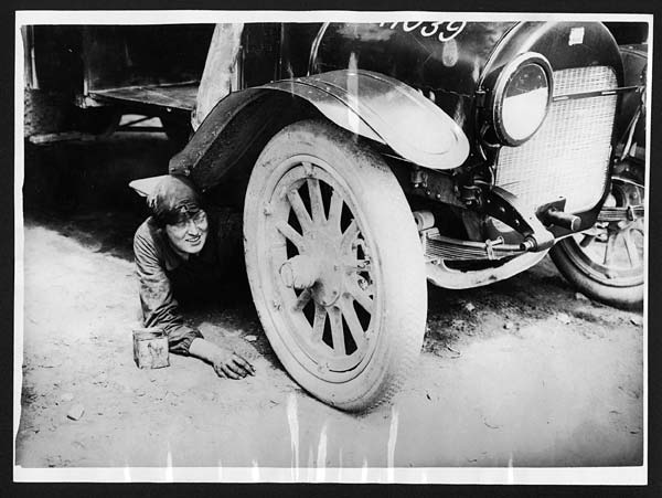 (276) C.1951 - One of the lady ambulance drivers underneath her car attending to something that has gone wrong