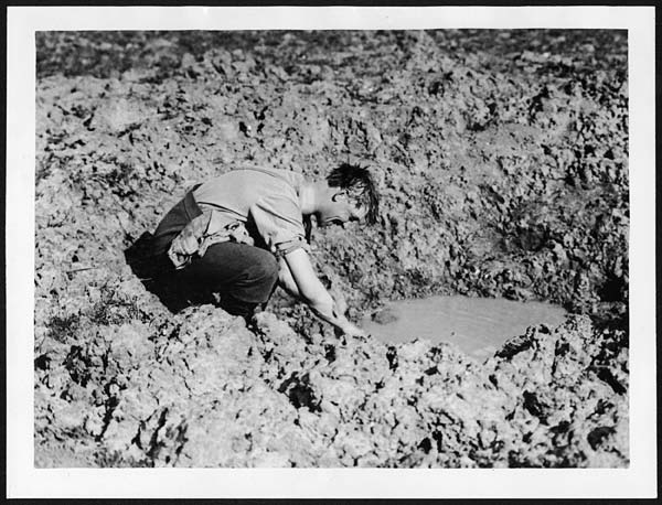 (133) X.34037 - Tommy washing in a shell hole