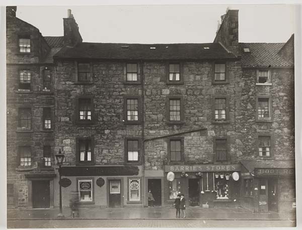 (14) View of a street of three storey tenement buildings with shops on the ground floor