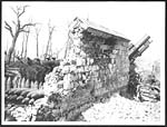 D.1272Howitzer in action beside a shell-stricken wall